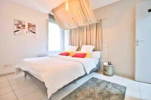 图卢兹*T2*Vue Garonne*Piscine*Garage*的卧室配有一张带彩色枕头的大型白色床。