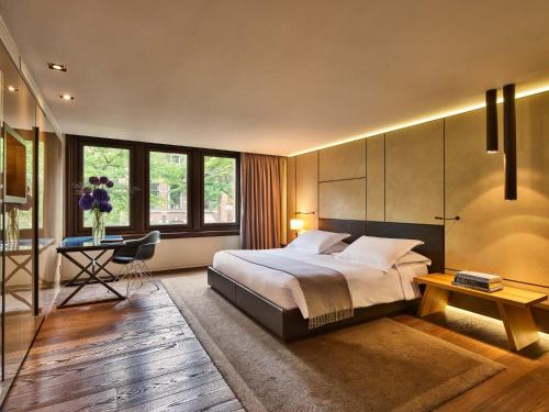 阿姆斯特丹Conservatorium Hotel的一间卧室配有一张大床和一张书桌