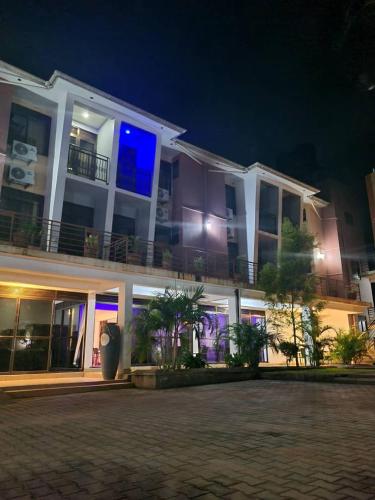 MbaleMountain Inn Hotel的一座白色的大建筑,晚上设有阳台