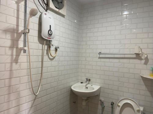 双溪林明OYO 90971 Pollock Homestay的带淋浴和盥洗盆的白色浴室