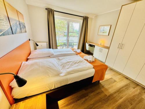 瓦尔内明德Landhaus Immenbarg, Wellness的一间卧室设有一张大床和一个窗户。