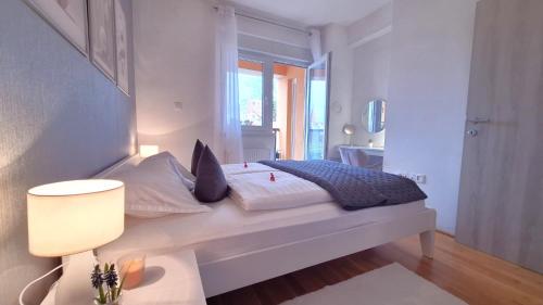 奥西耶克Apartman Lucille的白色的卧室设有床和窗户