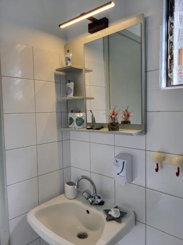基尼拉Aura Guesthouse的白色的浴室设有水槽和镜子
