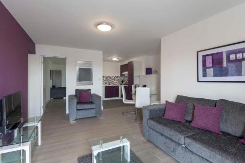 拉夫堡SAV Apartments Clarence Street-Loughborough的客厅配有灰色沙发和紫色枕头