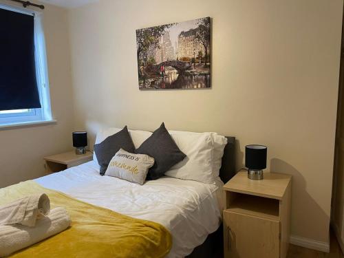 沃特福德SAV 1 Bedroom Flat near Watford Town Centre的卧室配有一张床,墙上挂有绘画作品