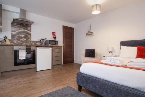 莱斯特SAV Apartments Regent Leicester的一间带大床的卧室和一间厨房