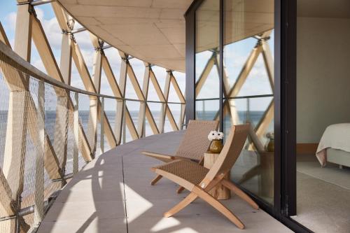米德尔克尔克C-Hotels Silt的带阳台的带两把椅子的房间