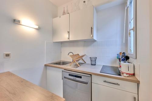 巴黎L'Augustine - Appartement dans le 15e的小厨房配有白色橱柜和水槽