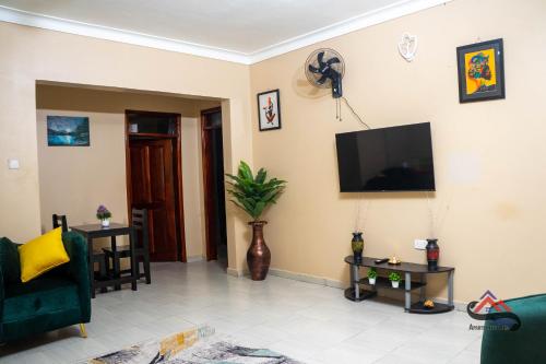 LiraKica Apartment with Airconditioned bedrooms in Lira, Uganda的客厅的墙上配有平面电视。