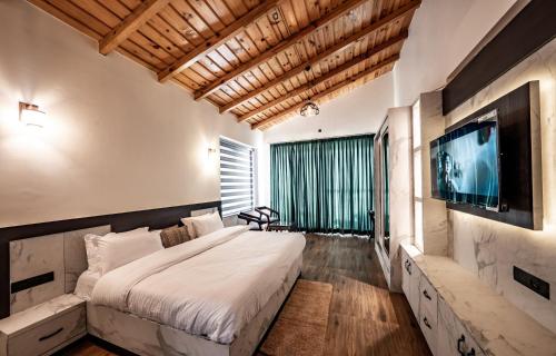 奈尼塔尔sunset villa的一间卧室配有一张大床和一台平面电视