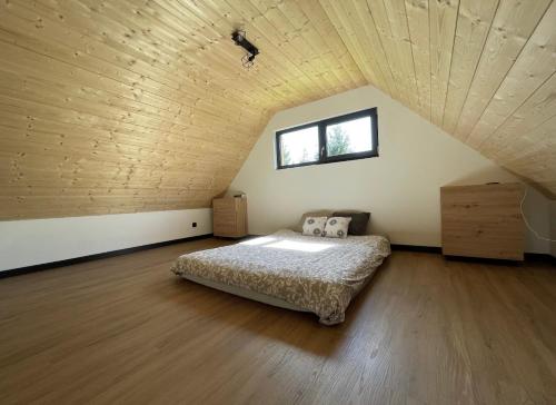 LudwinDom na Pojezierzu Łęczyńsko - Włodawskim的一间卧室设有一张床和木制天花板