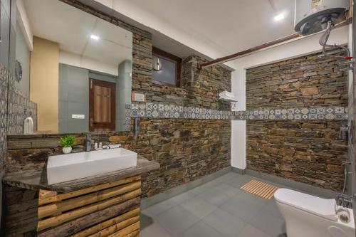 西姆拉Hotel Wood Winds - Best Hotel in Chail的一间带水槽和石墙的浴室