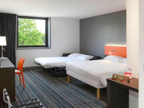 凯恩卡昂中心火车站宜必思样尚品酒店的酒店客房设有两张床和窗户。