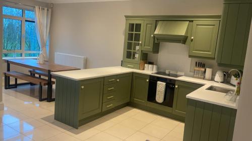 基勒纳德Sawgrass Killinard的厨房配有绿色橱柜和桌子