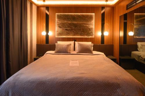 斯科普里Hotel Macedonia Square的一间卧室配有一张大床和两个枕头