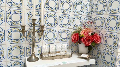 拉帕洛Bellaria II的浴室拥有蓝色和白色的瓷砖墙壁,配有鲜花桌