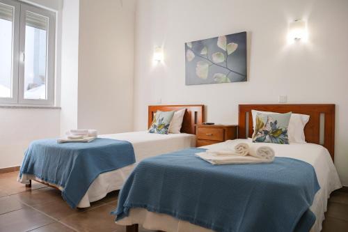 雷根古什-迪蒙萨拉什Casa do Castelo的一间设有两张床铺和毛巾的房间