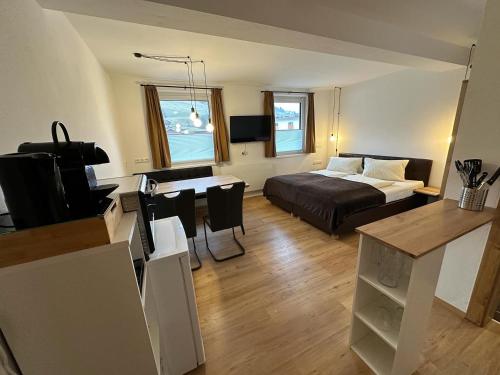 萨尔巴赫Willi‘s Studio的客厅配有一张床和一张书桌及电视