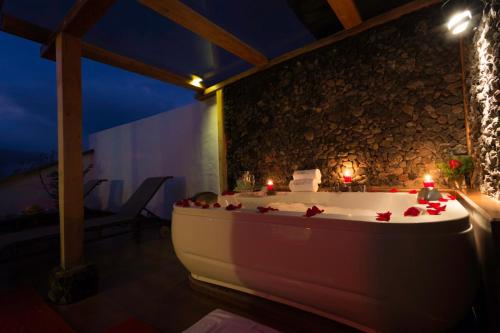 巴尼奥斯Luna Volcán, Adventure SPA的浴缸位于带蜡烛的房间