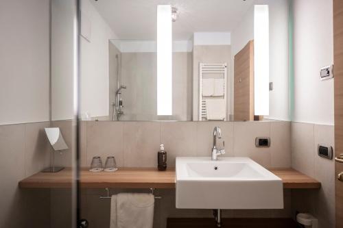 圣杰内肖阿泰西诺Hotel & Gasthof zum Hirschen的一间带水槽和镜子的浴室