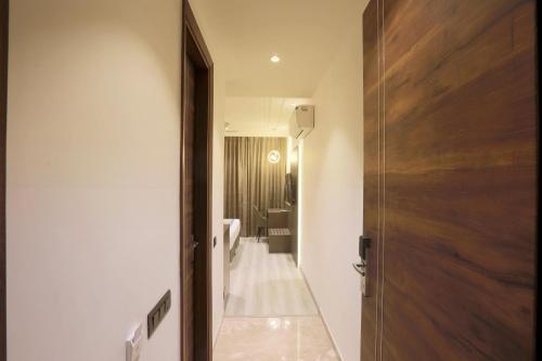 新德里OPO Hotels D'or的一间带卫生间的浴室和一扇通往客房的门