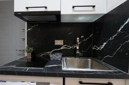 地拉那Niki’s Apartments的厨房配有水槽和黑色台面
