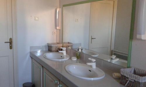 Grenade-sur-lʼAdourStudio de Tourisme Tilleuls的一间带两个盥洗盆和大镜子的浴室