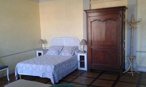 Grenade-sur-lʼAdourStudio de Tourisme Tilleuls的卧室配有白色的床和木制橱柜。