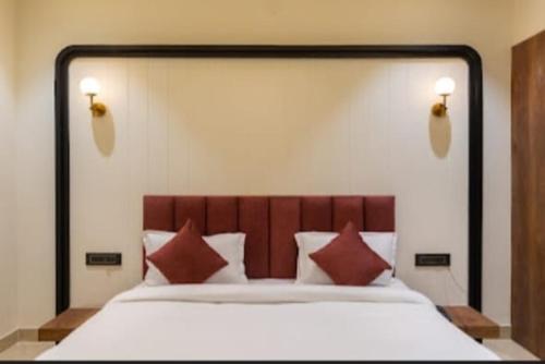 乌代浦Vaibhavya Hotel & Restaurant udaipur的一间卧室配有一张带红色枕头的大床