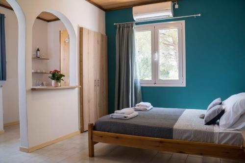 拉基索拉Aroma Studios的蓝色的卧室设有床和窗户