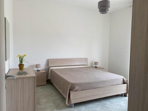 里里耶沃Sole, mare e trallallà的一间卧室配有一张床、两个床头柜和一张四柱床