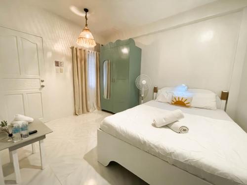 长滩岛Caleo Boracay Island Station 3的卧室配有一张白色的大床和一张桌子