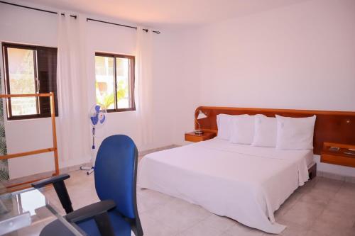 塔拉法尔Escape House的一间卧室配有一张床和一张蓝色椅子