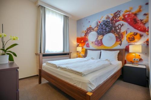 埃格尔Imola Udvarház Dessert Hotel的一间卧室配有一张壁画床