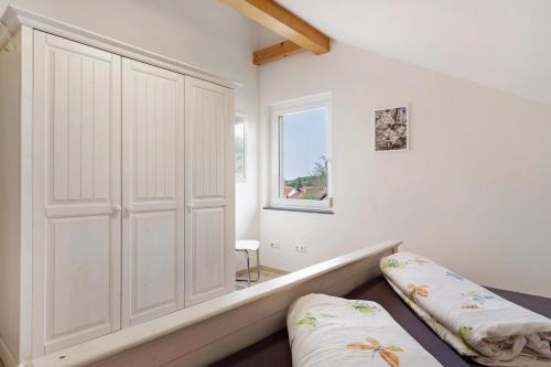 凯萨斯图尔地区萨斯巴赫Ferienwohnung In Der Weinig的卧室设有白色大衣柜和窗户。