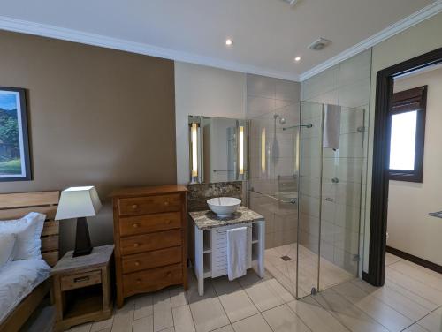 伊甸岛Maison Bigorno by Simply-Seychelles的带淋浴和盥洗盆的浴室以及1张床。