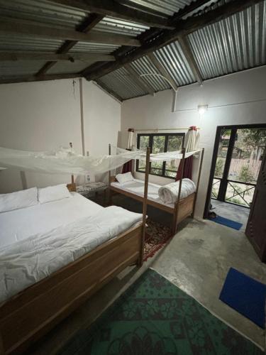 BhurkīāNanu's Bardiya Homestay的一间卧室设有两张双层床和一扇窗户。