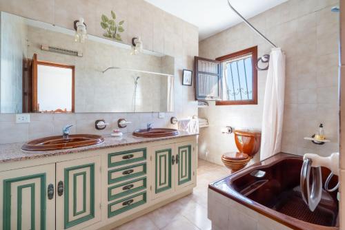 莫哈卡尔AlmeriaSuite Villa Los Carrillones Mojacar的一间带两个盥洗盆和大浴缸的浴室