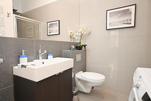 索波特Victus Apartamenty, Apartament Niebieski的浴室配有白色水槽和卫生间。