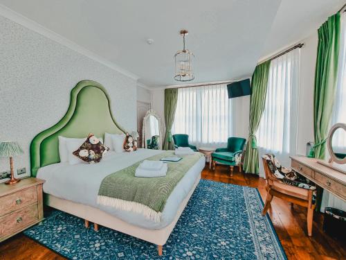 斯坦斯天鹅酒店的一间卧室配有一张大床和绿色床头板