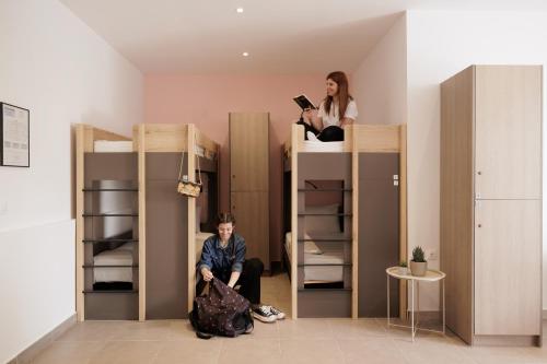 科孚镇Local Hostel & Suites的坐在双层床上的一个男人和一个女人