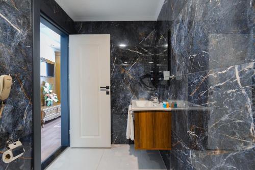 特拉布宗Berlin Suite Hotel Trabzon的一间带水槽和黑色大理石墙壁的浴室
