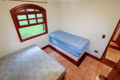 伊比乌纳LINDA Chácara - IBIÚNA - Condomínio的客房设有两张床和窗户。