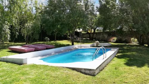 特拉武科新镇6 bedrooms villa with private pool enclosed garden and wifi at Villanueva del Trabuco的草地上的游泳池,配有两张床