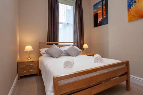 巴斯※ Spacious, Central Bath Apartment ※的一间卧室配有一张带白色床单的床和一扇窗户。
