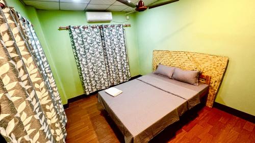 巴拉特布尔Paris Guest House Airport的一张小床,位于带绿色墙壁的房间里