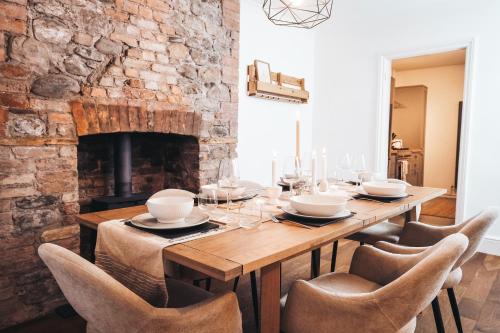BellaghyPye Corner Cottage, by Solace Stays的一间带木桌和壁炉的用餐室