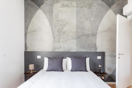 乌迪内Residence Moretti Piano Terra的卧室配有白色的床和带拱门的墙壁