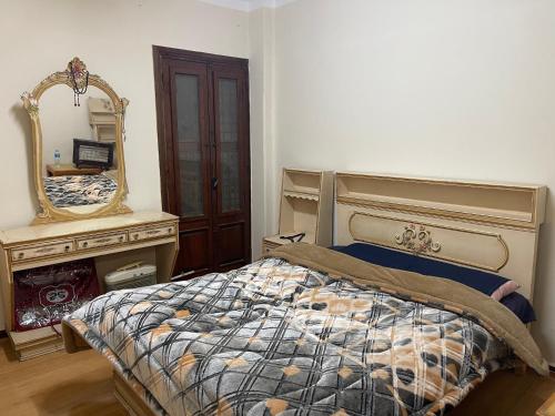 伊斯梅利亚Elnoras city ismailia的一间卧室配有一张带镜子和梳妆台的床
