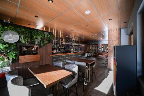 阿林萨尔Ushuaia, The Mountain Hotel的一间带桌椅的餐厅和一间酒吧